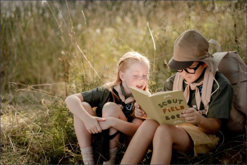 Scouts With Their Field Guide Book Youth scouts on field trip looking through their scouts field book.
